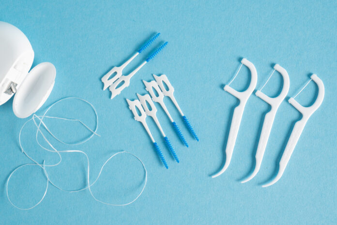 Happy young woman standing outside and putting on helmet