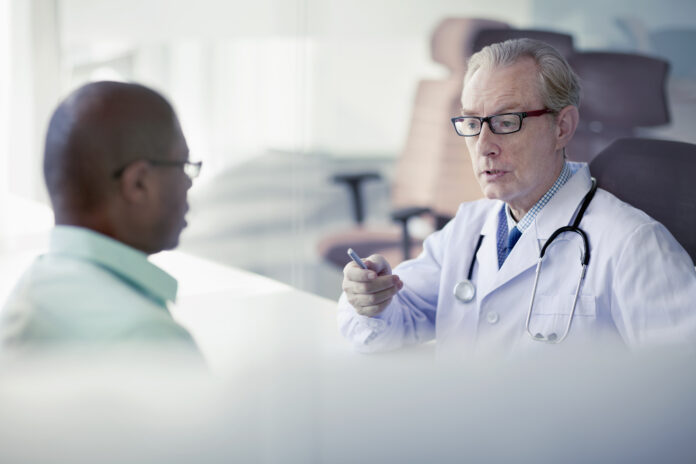 Doctor talking to patient at desk in office