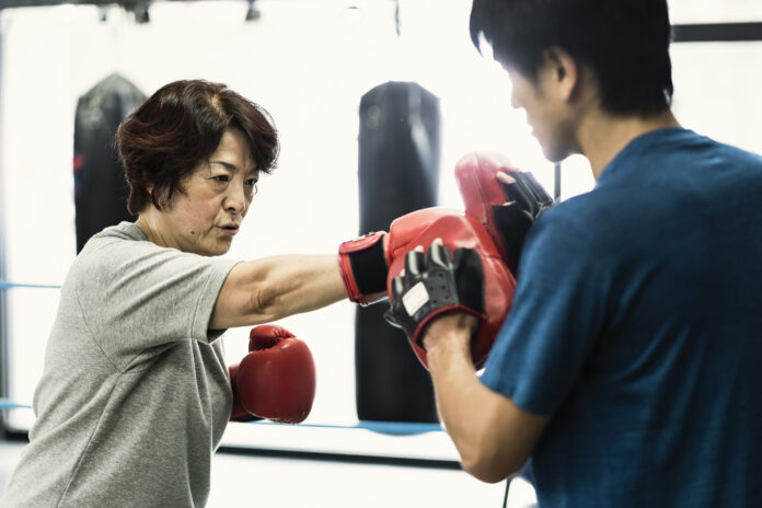 Senior adult women training with male instructor at boxing gym Fitness Boxing